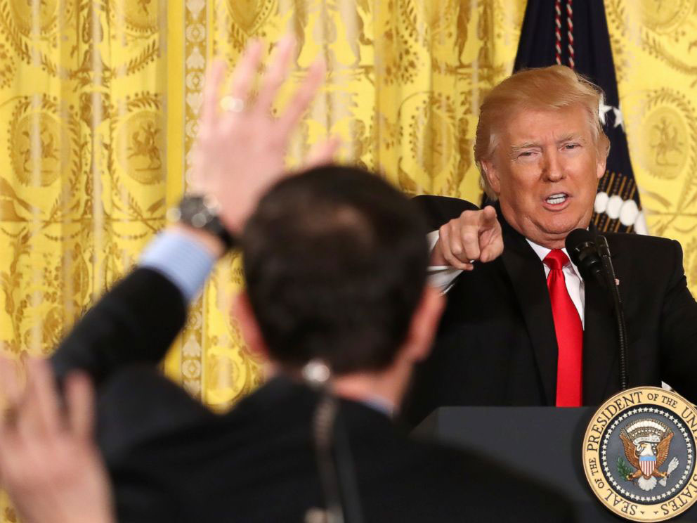 A photo shows President Donald Trump taking reporters’ questions at a news conference in the East Room of the White House.
